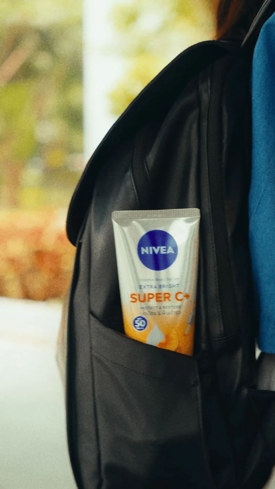 A still from the ad, a NIVEA Super C+ sunscreen tucked into the side pocket of a black backpack.