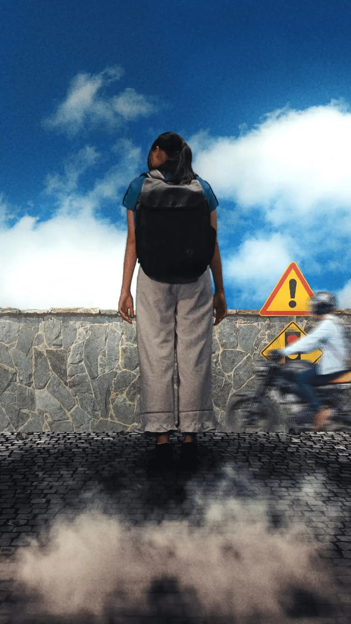 A still from the ad, a student with a backpack standing on a stone wall under a blue sky, beside a warning sign and a passing cyclist.